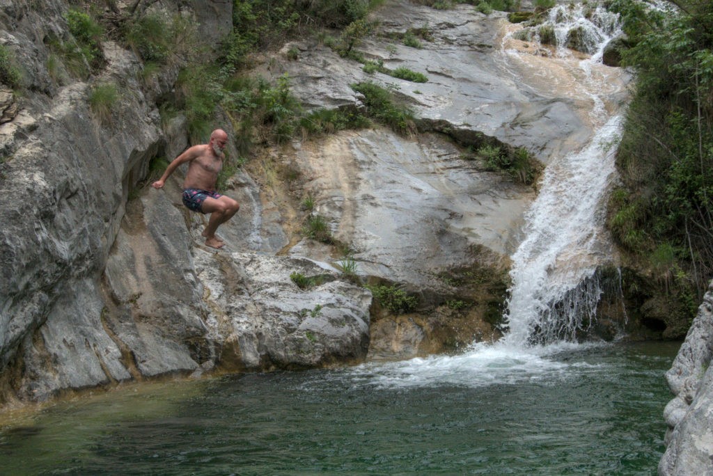 Cyclist is jumping into a river stream to get cooled off - mt Olympu