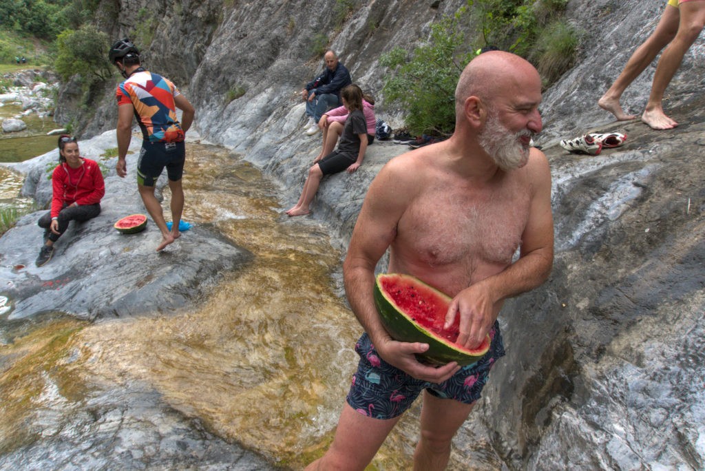 Cyclists enjoy a fresh watermelon during their break