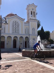 A cyclist posing in front of an iconic church in Keratea