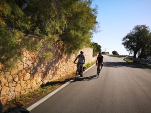 Two cyclists cycling on the coastal roads of Aegina island