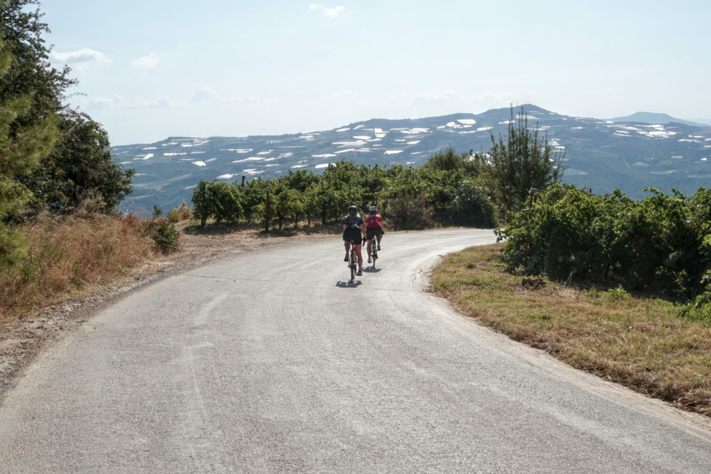 Two female cyclists on a winding vine road in Nemea Greece